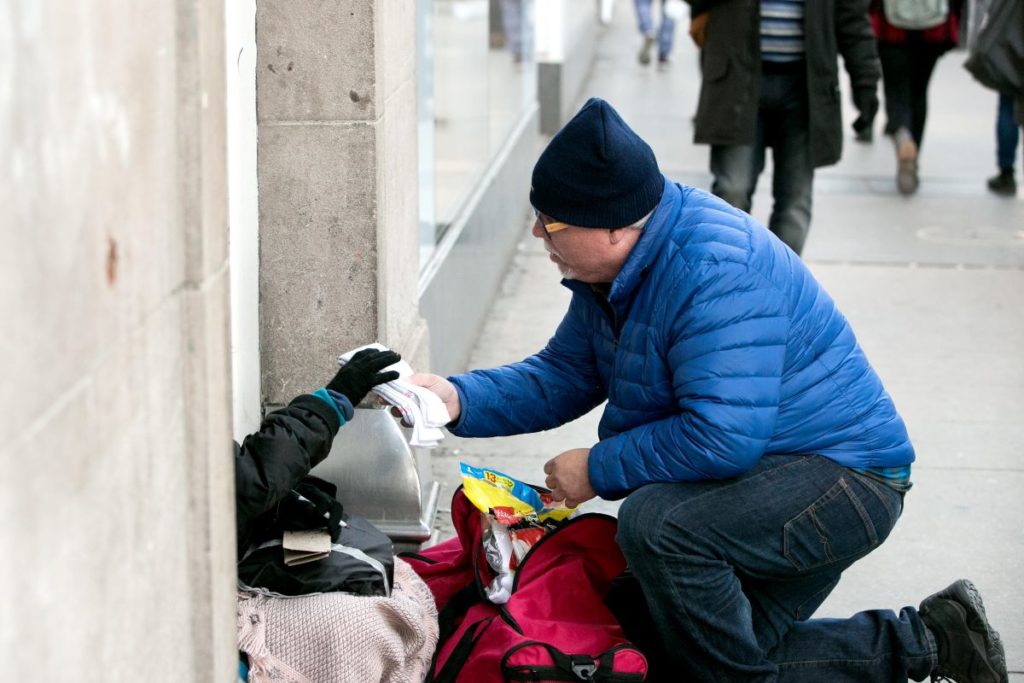 man giving to homeless
