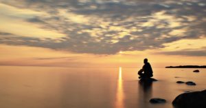 man-silhouette-contemplation-muraqabah-rock-ocean-sunlight