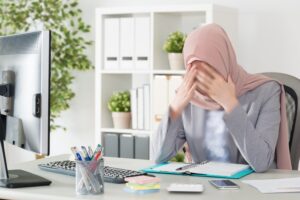 sad Muslim lady working at office